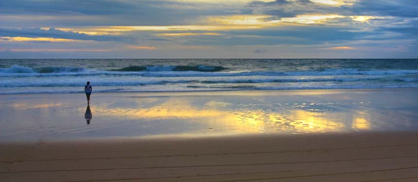 A person walking along a beach