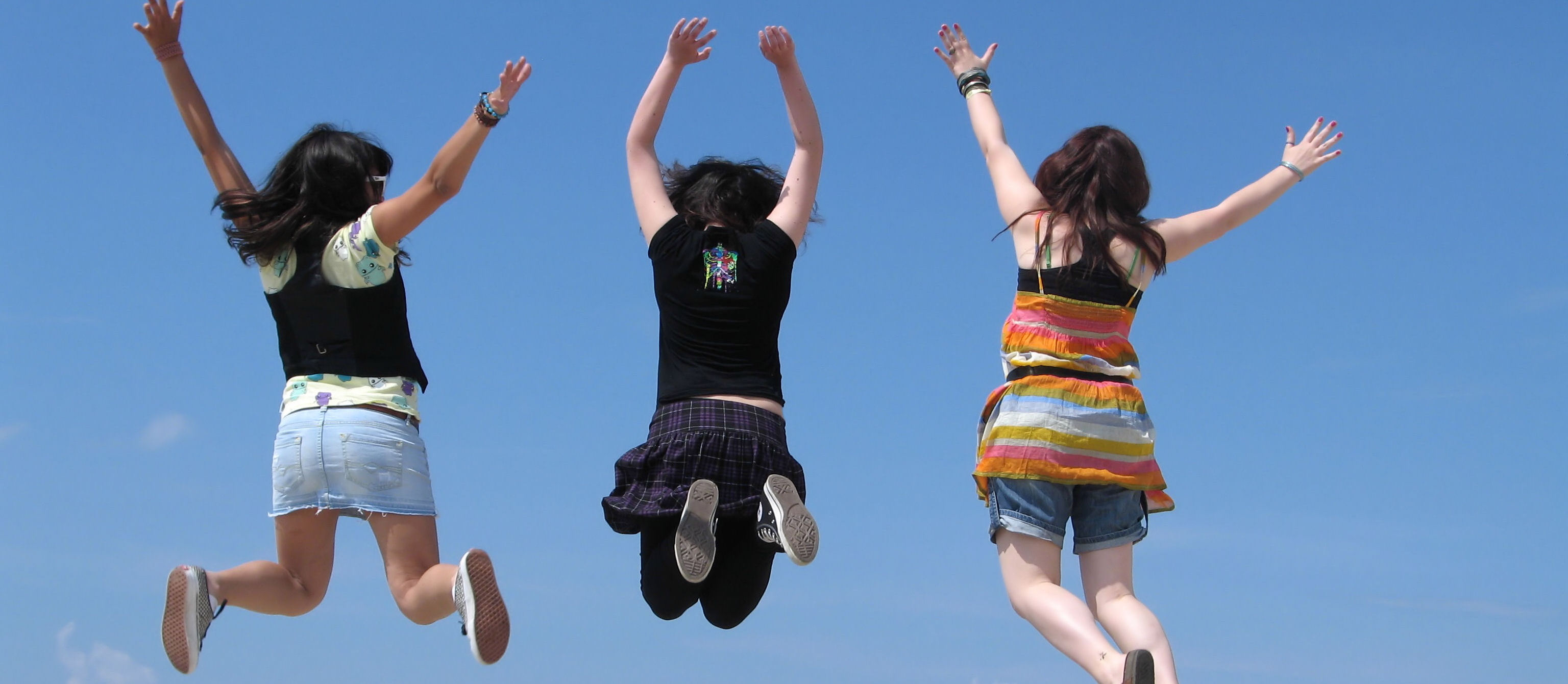 three young girls jumping in the air